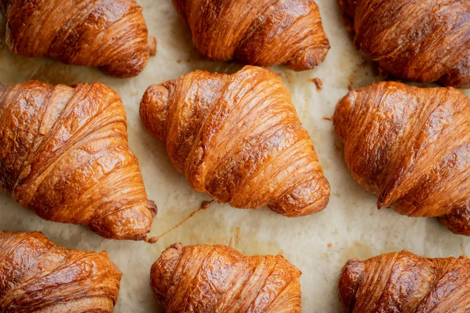 Golden croissants arranged on a baking surface, shown as bakery inspiration